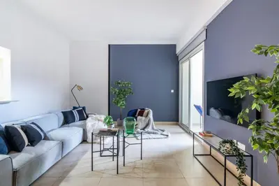 a living room with blue walls and a couch at The Smart Concierge - Plaza residence in Dubai