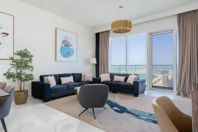 a living room with a blue couch and a large window at ON OFF HH-AVANI HOTEL-3BR -Full Palm View in Dubai