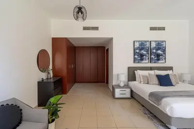 a bedroom with a bed and a chair and a mirror at HiGuests - Stylish Apartment in JBR Steps From the Beach in Dubai