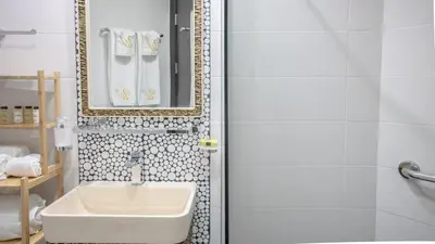 a white bathroom with a sink and a mirror at AWS Holiday Homes - Luxury Living besides Canal in Dubai