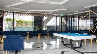 a lobby with a pool table and blue chairs at AWS Holiday Homes - Luxury Living besides Canal in Dubai