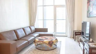 a living room with a couch and a television at AWS Holiday Homes - Luxury Living besides Canal in Dubai