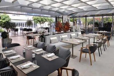 a restaurant with tables and chairs and windows at Emaar Residences in Dubai