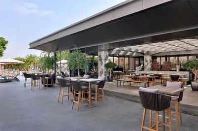a patio with tables and chairs and a building at Emaar Residences in Dubai