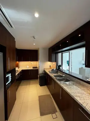 a kitchen with wooden cabinets and a large window at Burj Khalifa view, 3 Bedroom Apartment in Boulevard Point, Connected to Dubai Mall in Dubai