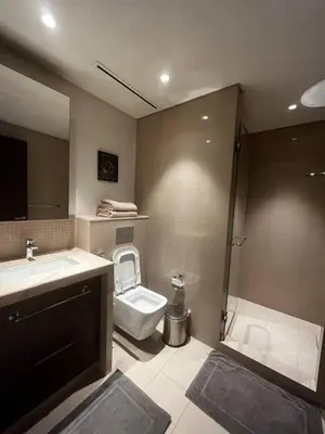 a bathroom with a toilet and a sink and a shower at Burj Khalifa view, 3 Bedroom Apartment in Boulevard Point, Connected to Dubai Mall in Dubai