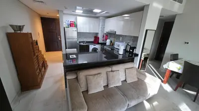a living room with a couch and a kitchen at Elegant and comfortably furnished 2BRH apartment in a quiet area! in Dubai