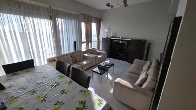 a living room with two chairs and a table and a television at Elegant and comfortably furnished 2BRH apartment in a quiet area! in Dubai