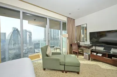a hotel room with a couch and a television and a desk at Emaar Fashion Avenue - Formerly Address Dubai Mall Residence in Dubai