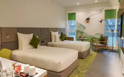 a hotel room with two beds and a table at Al Khoory Courtyard Hotel in Dubai