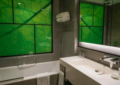 a bathroom with a sink and a green window at Al Khoory Courtyard Hotel in Dubai