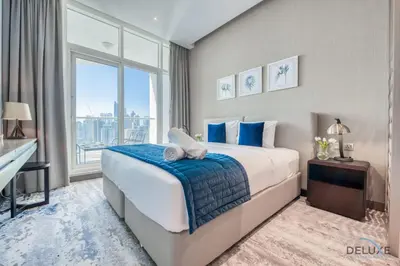 a bedroom with a large bed and a large window at Damac Maison Prive Deluxe Studio with Water Canal View in Dubai