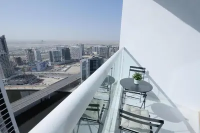 a balcony with a table and chairs on a building at Damac Maison Prive Deluxe Studio with Water Canal View in Dubai