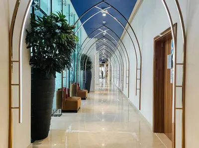 a hallway with a large plant in a building at Damac Maison Prive Deluxe Studio with Water Canal View in Dubai