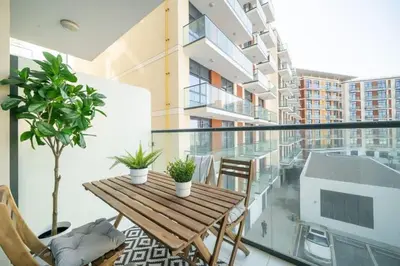 an apartment balcony with a wooden table and chairs at Frank Porter - DAMAC Celestia in Dubai