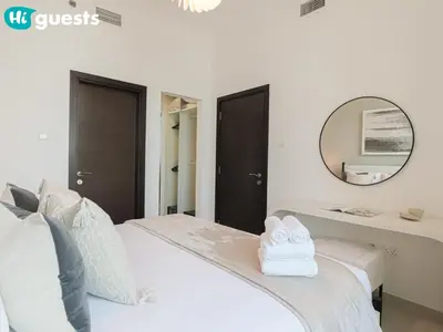 a bedroom with a white bed and a mirror at HiGuests - Exceptional Apt with Furnished Terrace By the Sea in Dubai