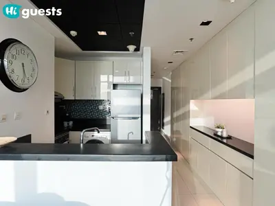 a kitchen with a sink and a clock on the wall at HiGuests - Exceptional Apt with Furnished Terrace By the Sea in Dubai