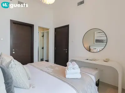 a bedroom with a white bed and a mirror at HiGuests - Exceptional Apt with Furnished Terrace By the Sea in Dubai