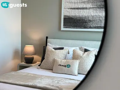 a bedroom with a bed with white sheets and pillows at HiGuests - Exceptional Apt with Furnished Terrace By the Sea in Dubai