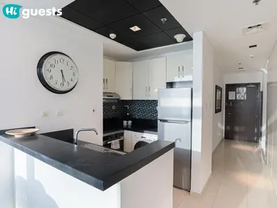 a kitchen with a large clock on the wall at HiGuests - Exceptional Apt with Furnished Terrace By the Sea in Dubai