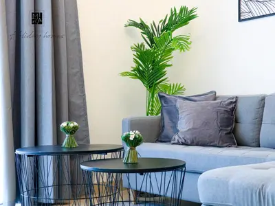 a living room with two tables in front of a couch at Mira Holiday Homes - Newly Furnished 1 bedroom in Creek Vista Tower B Sobha Hartland in Dubai
