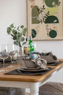 a dining room table with plates and wine glasses at Frank Porter - Executive Tower F in Dubai