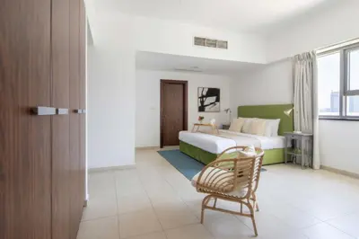 a hotel room with a bed and a chair at Frank Porter - Executive Tower F in Dubai