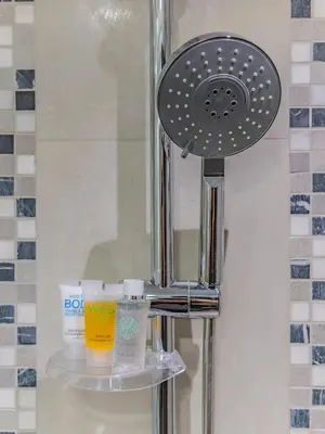a bathroom shower with a soap dispenser and toiletries at Charming Tropical Apartment Minutes To Dubai Mall in Dubai