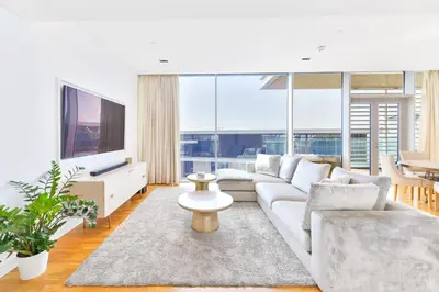 a living room with a white couch and a large window at Premium 2+1 BR condo in the heart of Bluewaters Island in Dubai