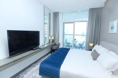 a hotel room with a large bed and a flat screen tv at DAMAC MAISON PRIVE in Dubai