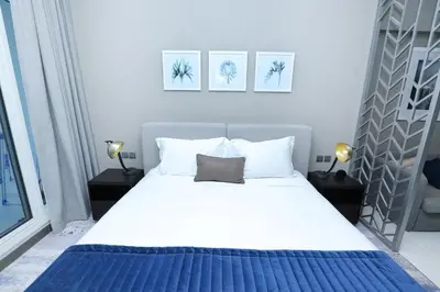 a bedroom with a large white bed with two lamps at DAMAC MAISON PRIVE in Dubai