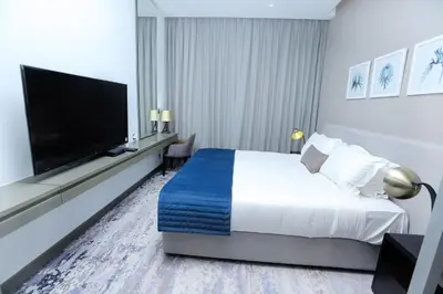 a hotel room with a bed and a flat screen tv at DAMAC MAISON PRIVE in Dubai