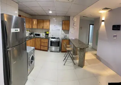 a kitchen with a stainless steel refrigerator and a counter at AlBarsha 1 Hostel by PHM in Dubai