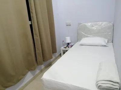 a white bed in a room with a window at AlBarsha 1 Hostel by PHM in Dubai