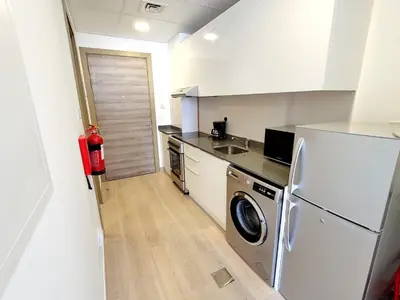 a kitchen with a refrigerator and a washer and dryer at Bloom Height Tower in Dubai
