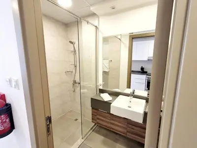 a bathroom with a sink and a glass shower at Bloom Height Tower in Dubai
