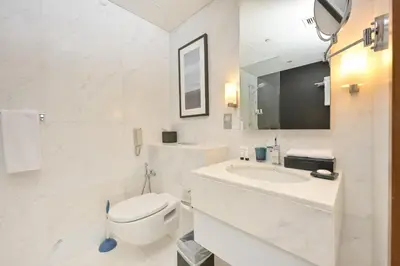 a white bathroom with a toilet and a sink at FAHH - Spacious Studio in Emaar Fashion Avenue in Dubai
