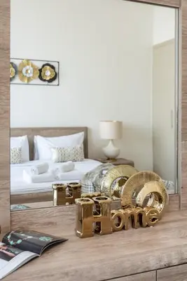 a bedroom with a mirror and a bed and a table at The Smart Concierge - Amna Tower in Dubai