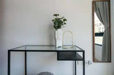 a glass table with a vase and a mirror at GuestReady Holiday Homes - The Green Scape in Dubai