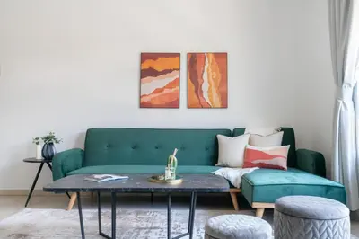 a living room with a green couch and a table at GuestReady Holiday Homes - The Green Scape in Dubai