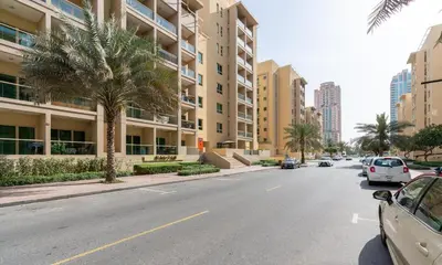 an empty street with palm trees and buildings at GuestReady Holiday Homes - The Green Scape in Dubai