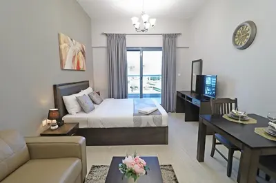 a bedroom with a bed and a living room at Spacious Apartment with Balcony Near Dubai Mall in Dubai