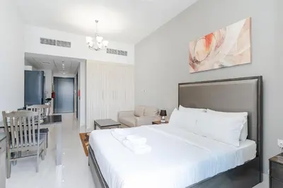 a bedroom with a large bed and a dining room at Spacious Apartment with Balcony Near Dubai Mall in Dubai
