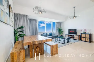 a living room with a table and a couch at LUX The Sky View Suite Dubai Marina in Dubai