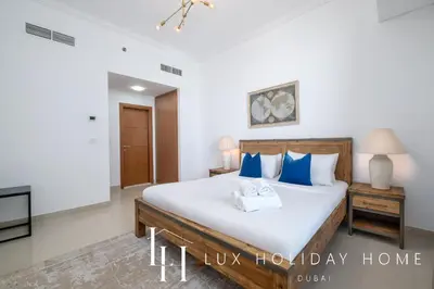 a bedroom with a bed with two towels on it at LUX The Sky View Suite Dubai Marina in Dubai