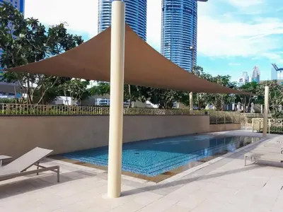 a large umbrella over a swimming pool with buildings at FIRST CLASS 3BR with full BURJ KHALIFA and FOUNTAIN VIEW in Dubai