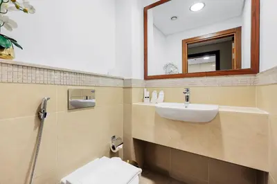 a bathroom with a sink and a toilet and a mirror at FIRST CLASS 3BR with full BURJ KHALIFA and FOUNTAIN VIEW in Dubai
