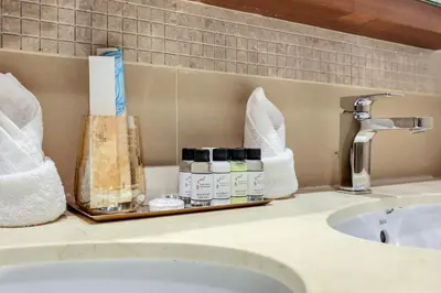 a bathroom counter with a sink and a shelf with cosmetics at FIRST CLASS 3BR with full BURJ KHALIFA and FOUNTAIN VIEW in Dubai