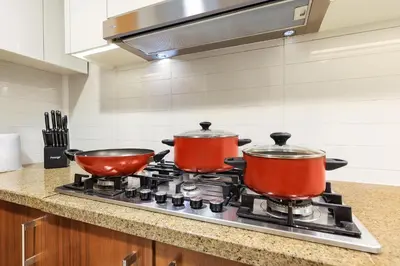 two pots on top of a stove in a kitchen at FIRST CLASS 3BR with full BURJ KHALIFA and FOUNTAIN VIEW in Dubai