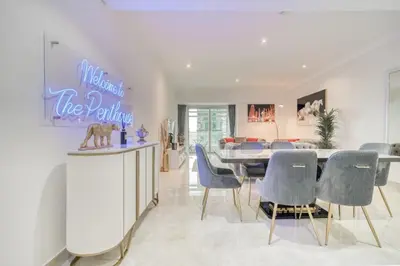 a dining room and living room with a table and chairs at The Marina PENTHOUSE near JBR 46th Floor in Dubai